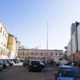 La piazza a cui si riferisce il giovane si trova sul retro del mercato ed � parte di via Tanzi, strada che costeggia l�autosilo e che si trasforma in una specie di largo chiuso da edifici particolari. Qui infatti si affaccia una storica e un po� abbattuta caserma dei Carabinieri dal colore rosa pallido...